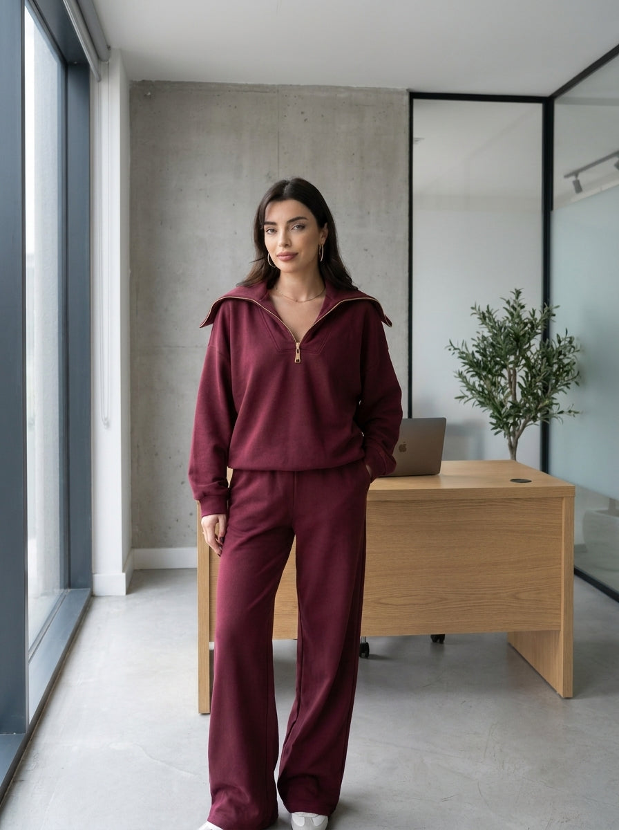 Femme portant l’ensemble demi-zip bordeaux à grand col et pantalon large, au bureau