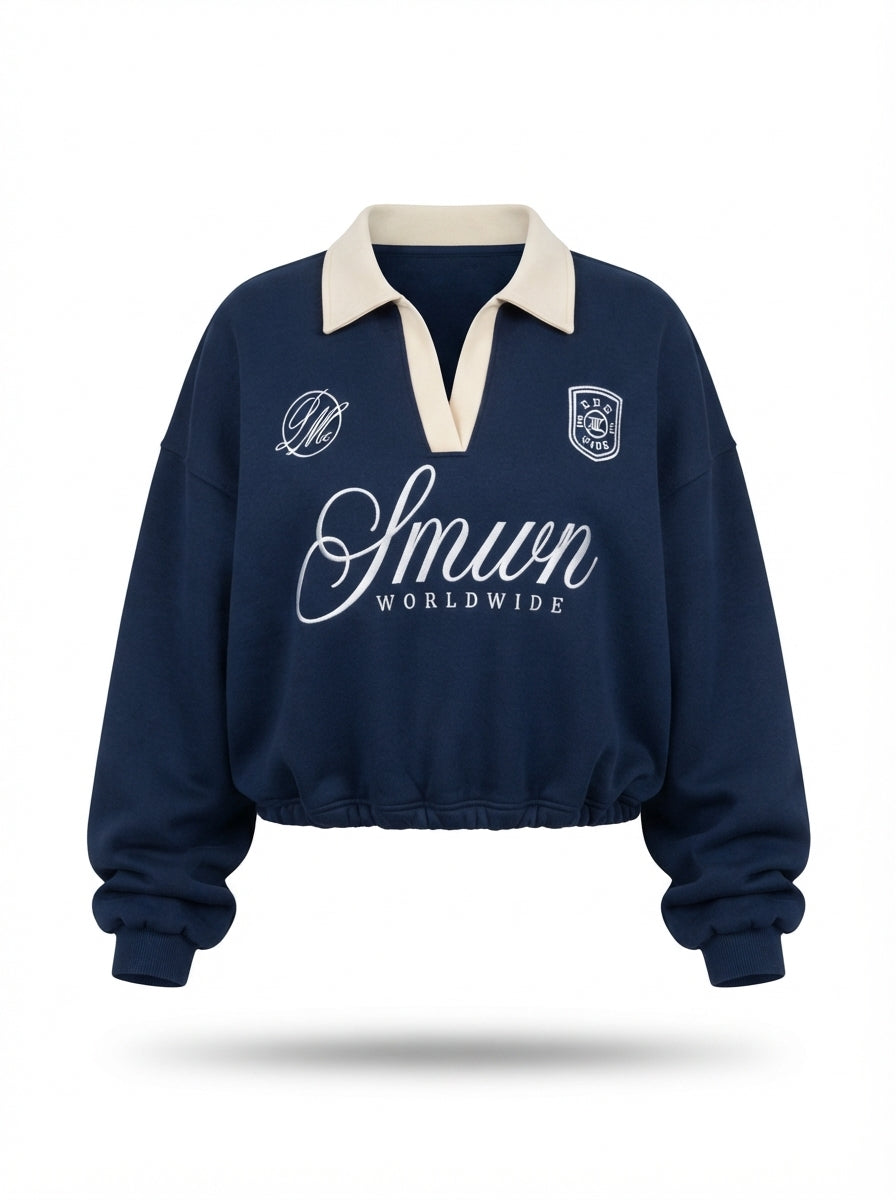 Sweat polo bleu marine à col crème et broderie blanche sur fond blanc