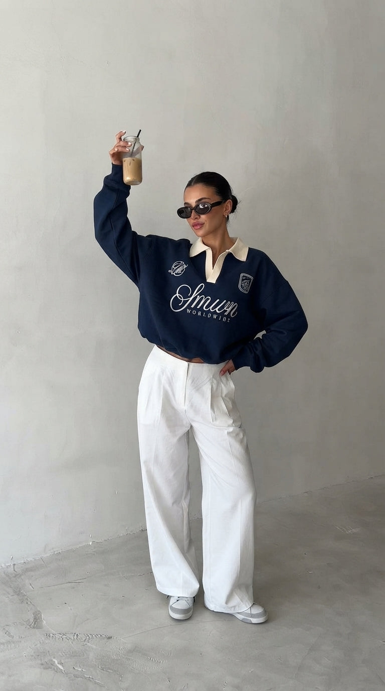Femme en sweat polo bleu marine levant un café glacé