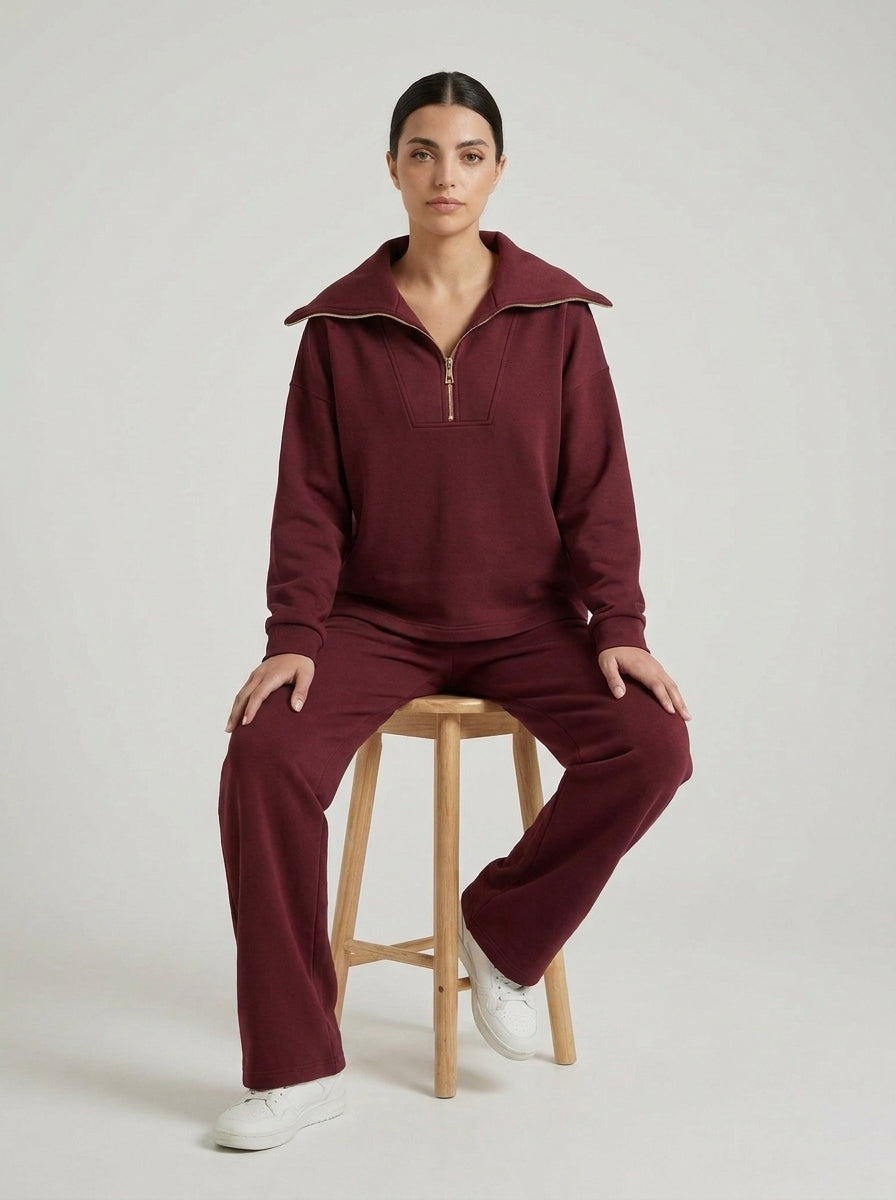 Ensemble bordeaux demi-zip porté assise sur un tabouret