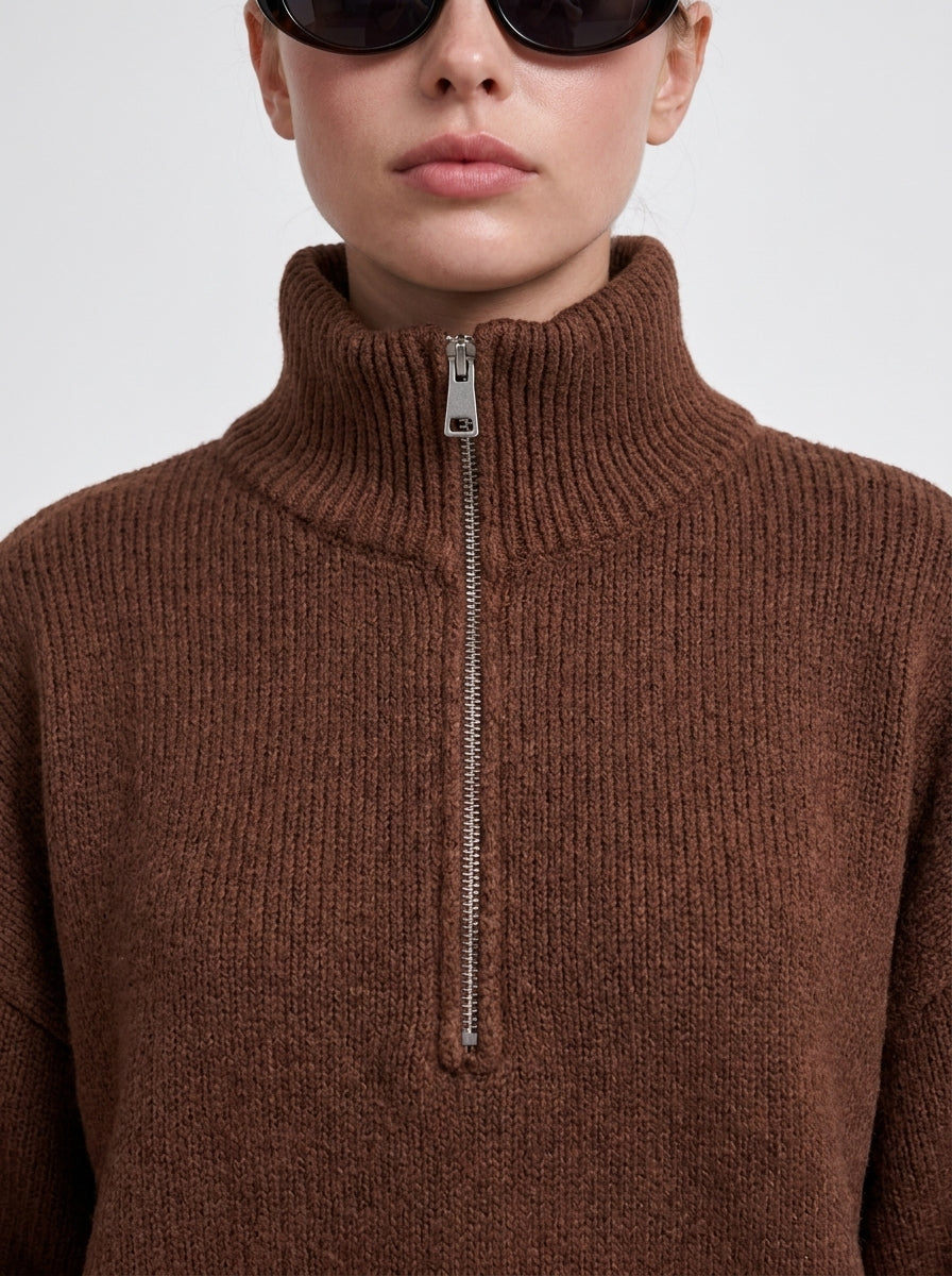 Gros plan de la maille et du zip du pull marron