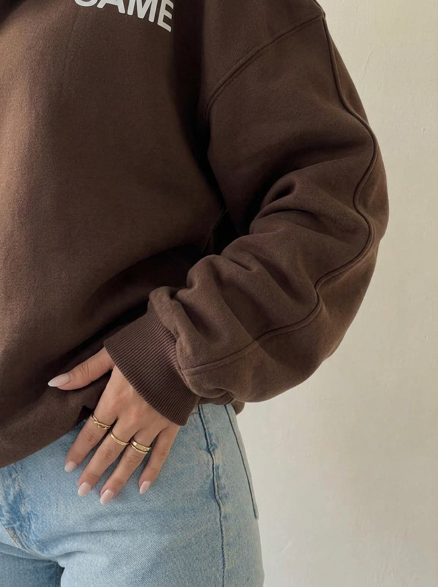 Détail de la manche ample et du poignet côtelé du sweat marron