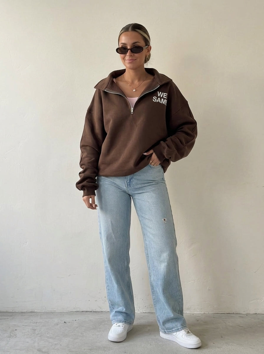 Femme portant le sweat demi-zip oversize marron chocolat avec un jean large