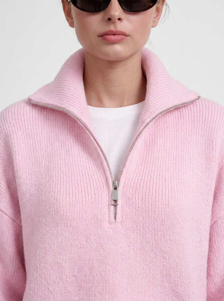 Gros plan du col et du zip du pull rose